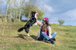 young woman  with border collie  dog playing on a green meadow